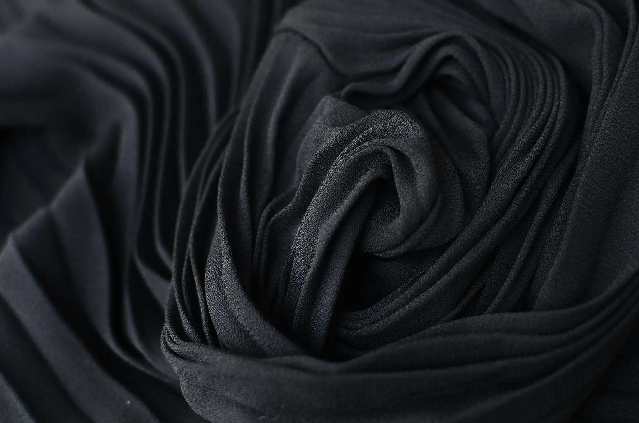 Close-up of black fabric with intricate folds and texture