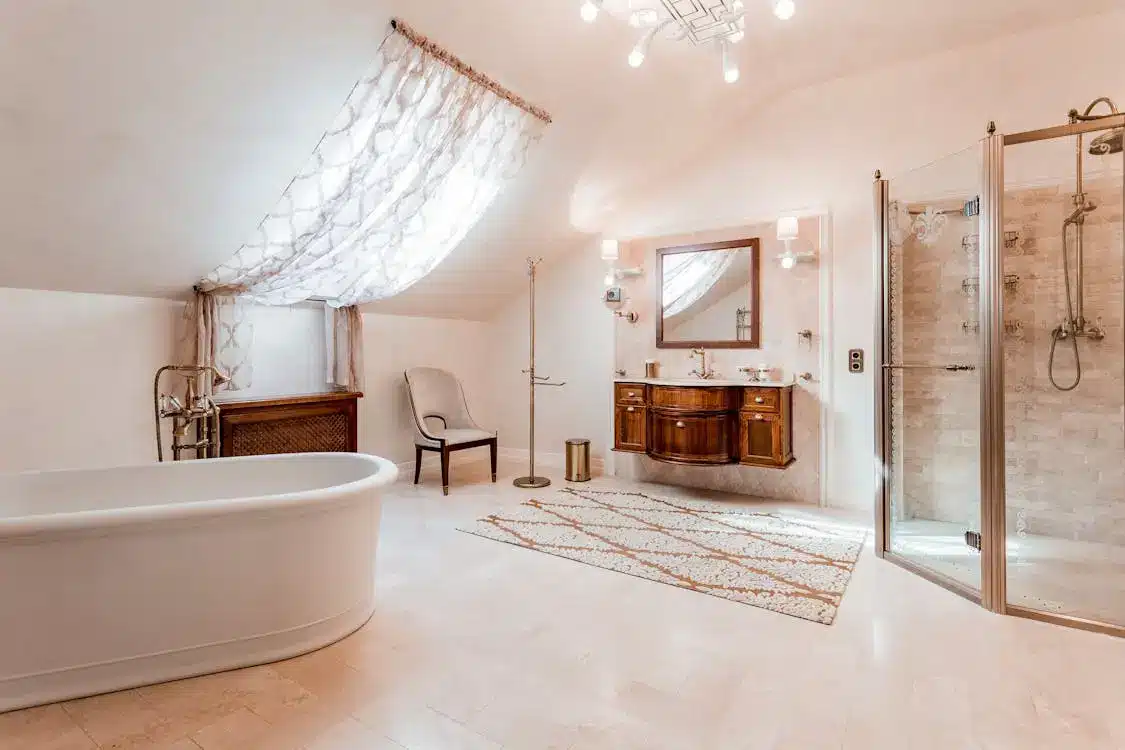 Elegant bathroom with white bathtub, glass shower enclosure, and wooden vanity in soft natural light