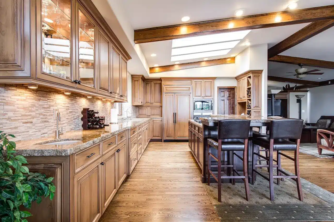 Spacious modern kitchen with wooden cabinetry, granite countertops, and island with bar stools