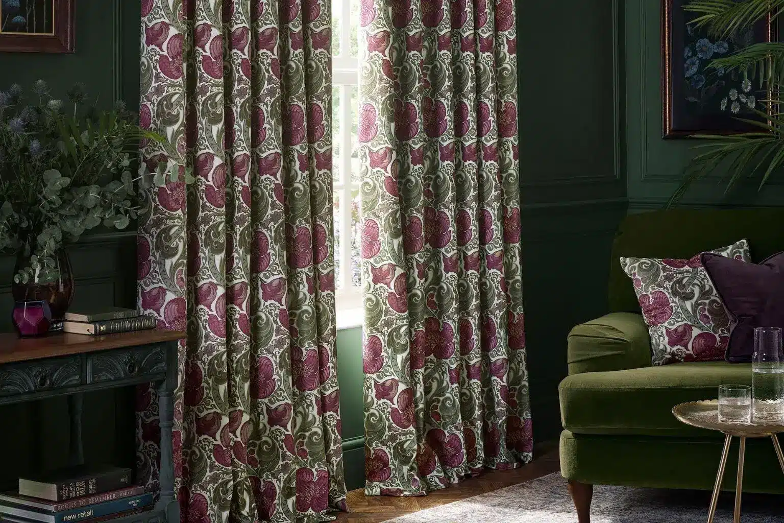 Vintage floral curtains in dark green living room with green sofa and decorative pillows