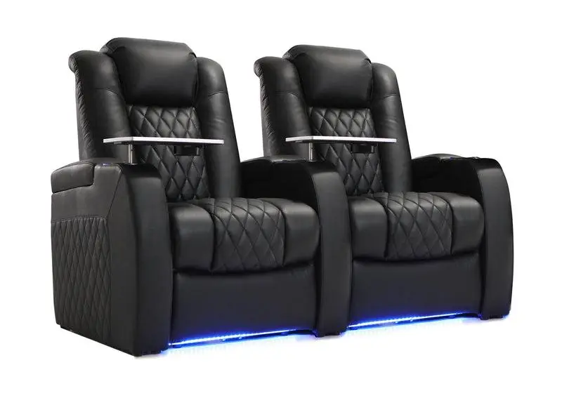 Two black leather recliner chairs with quilted design and built-in trays on a white background