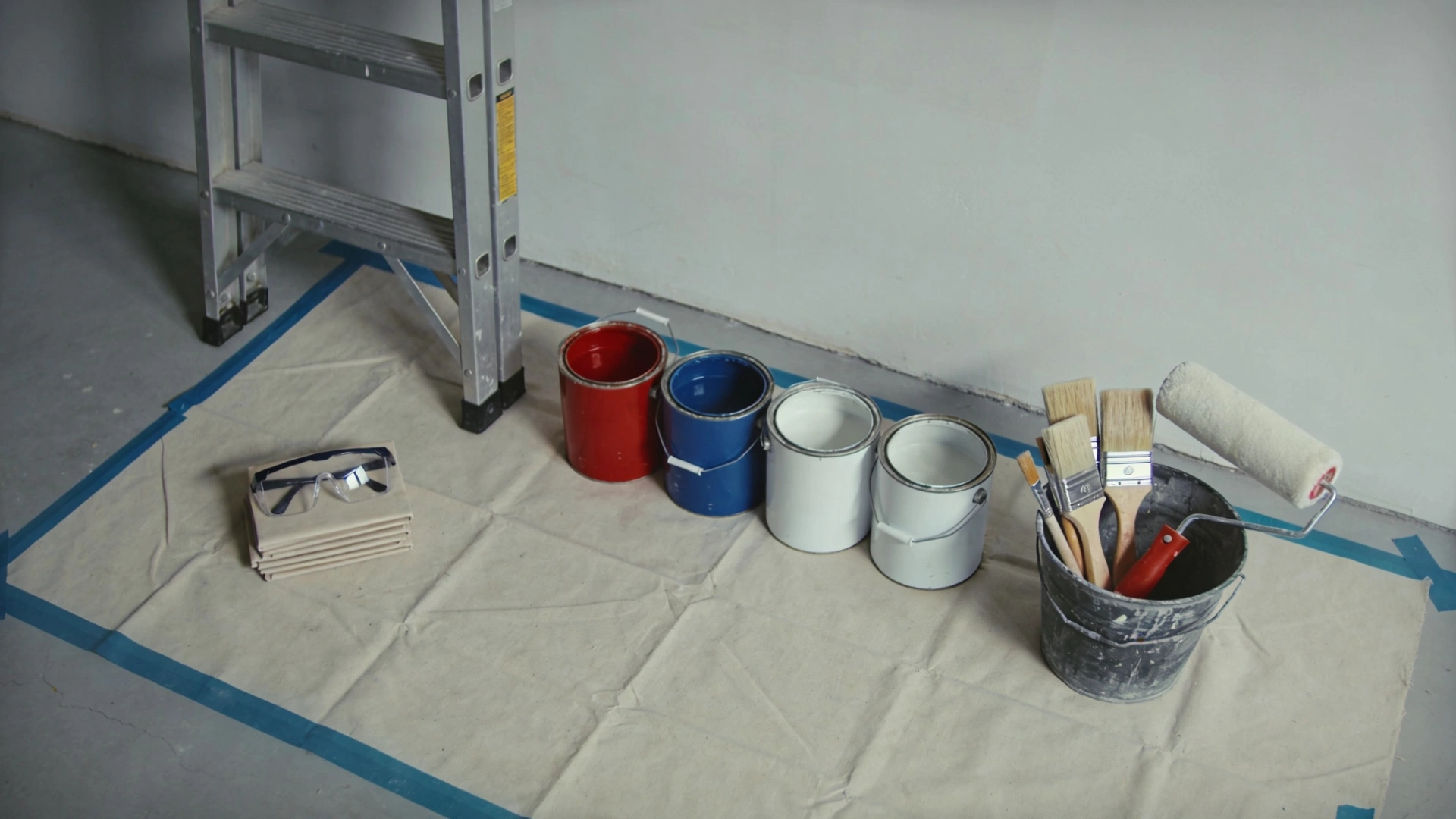 A collection of tools and paint supplies arranged on a table, showcasing brushes, paint tubes, and various instruments