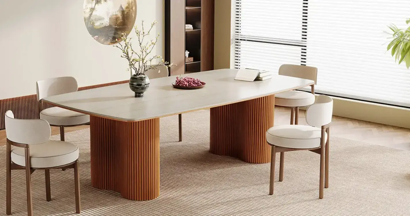 Modern dining room with wooden table, upholstered chairs, and decorative branches in vase