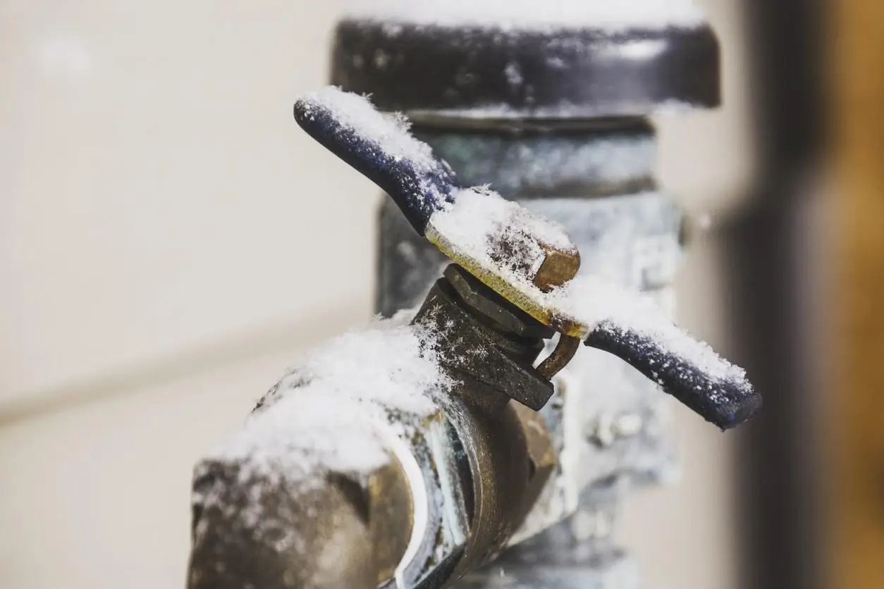 Close-up of an outdoor faucet covered in snow and frost