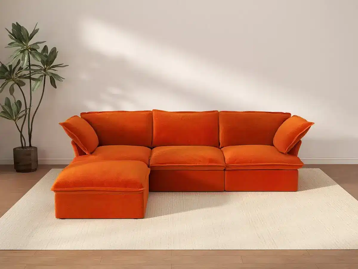 Bright orange sectional sofa with chaise in sunlit living room with potted plant