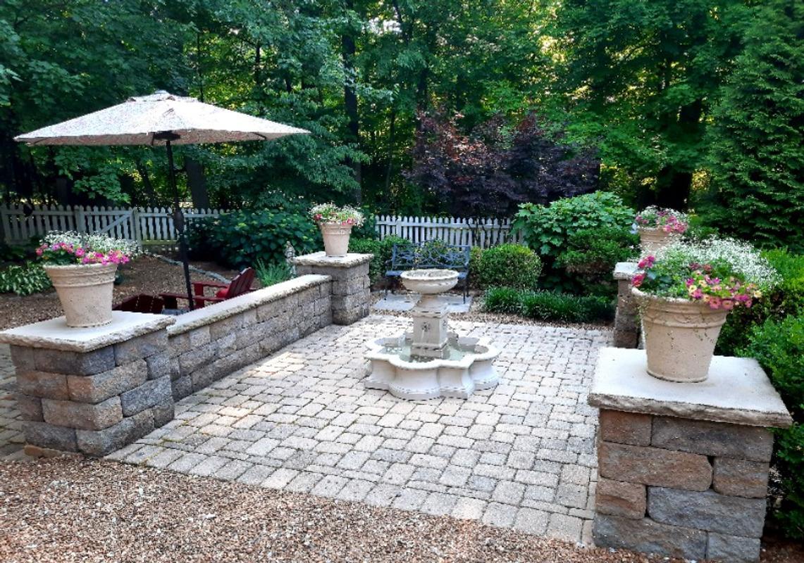 Landscaped patio with fountain and flowers.