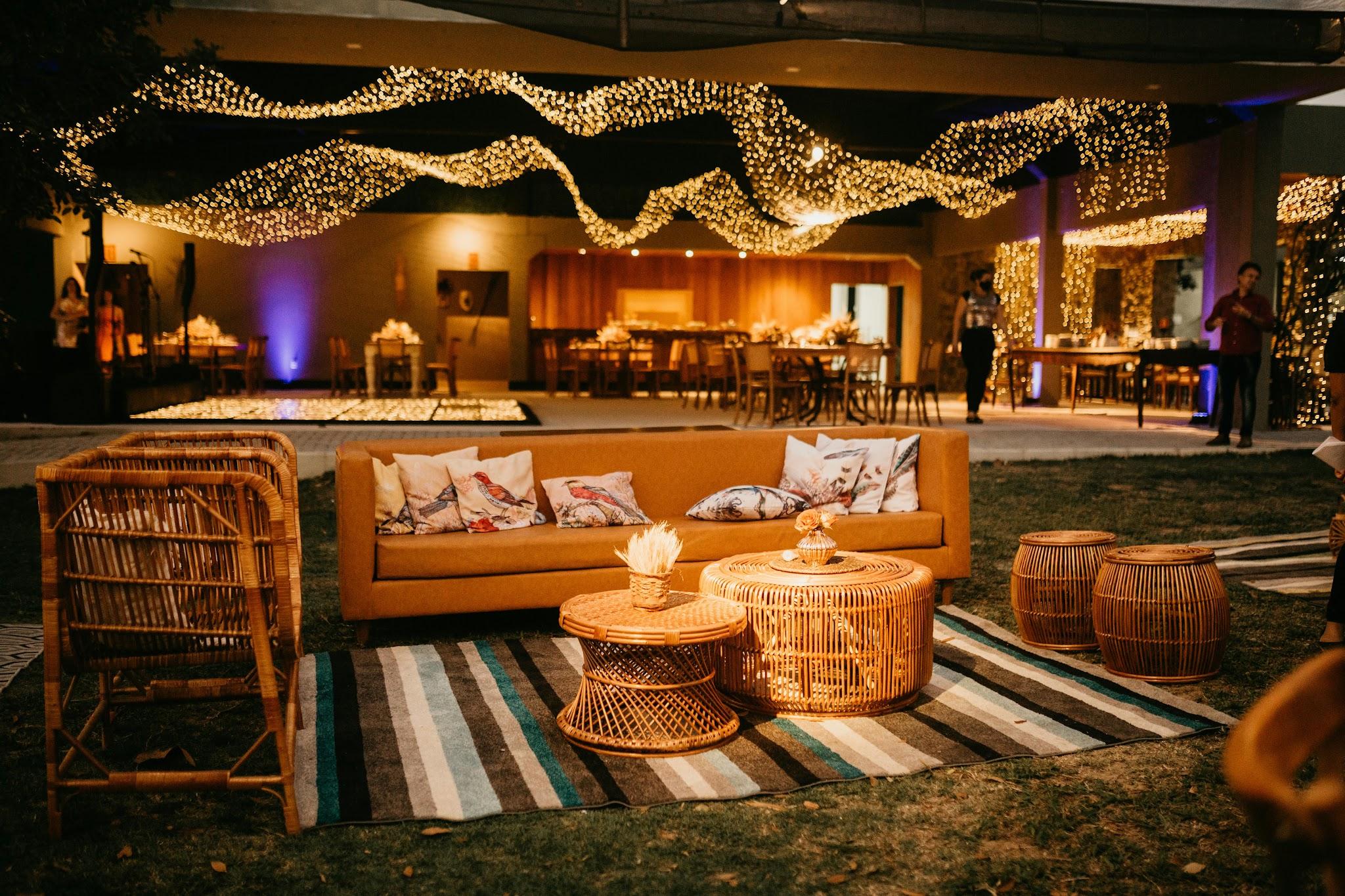 Outdoor seating with wicker furniture and ambient lighting.