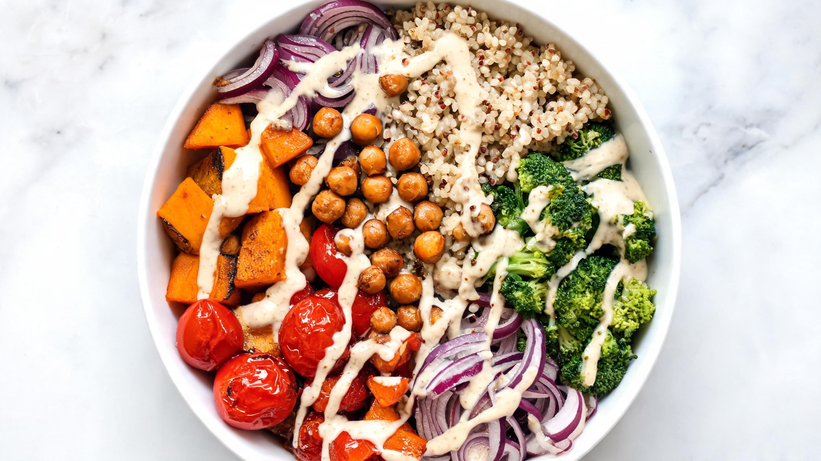 A colorful Buddha bowl with quinoa, roasted vegetables, and tahini dressing.