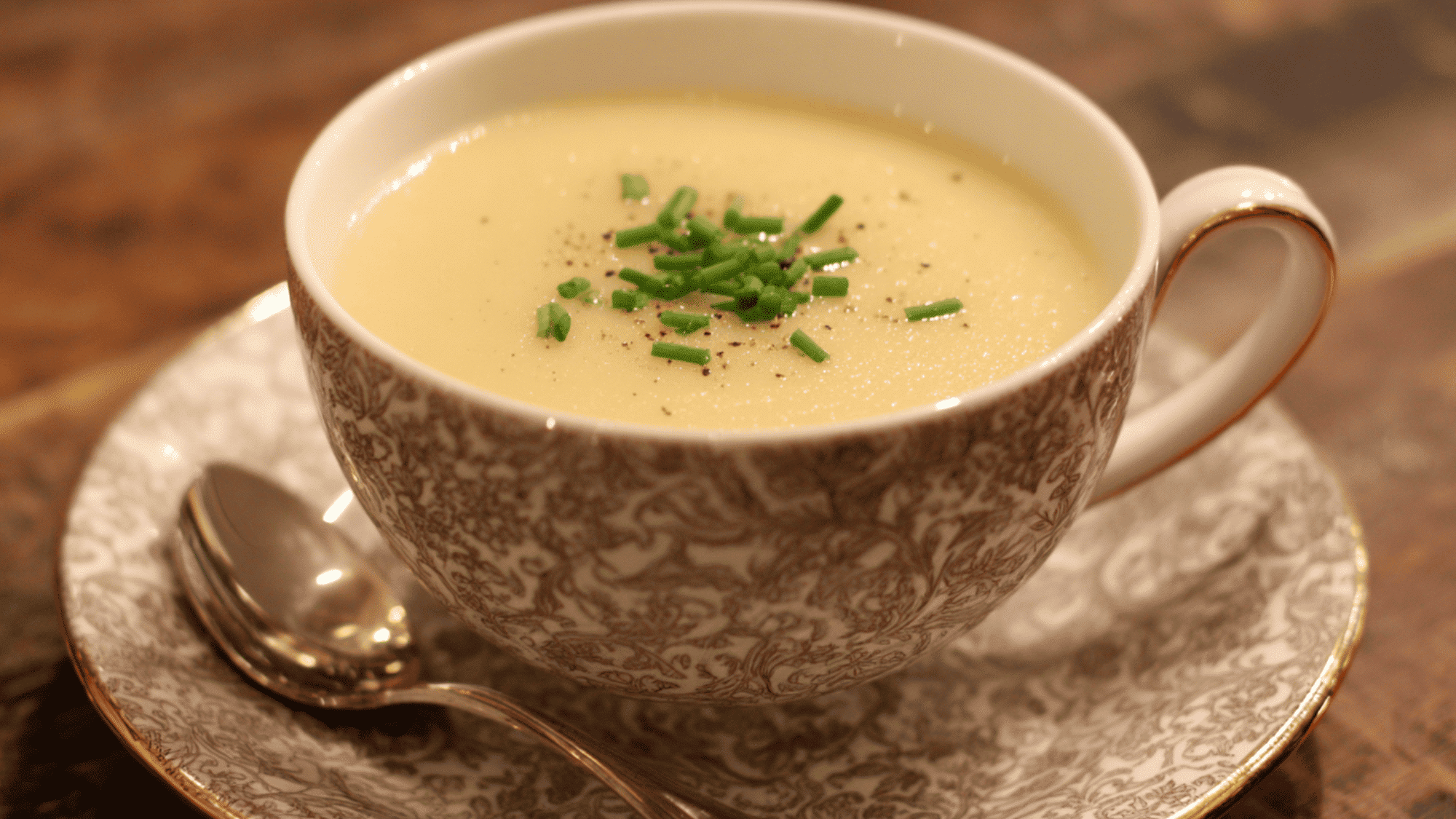 A comforting, smooth, and creamy potato soup simmering inside a slow cooker, lightly seasoned with fresh herbs.