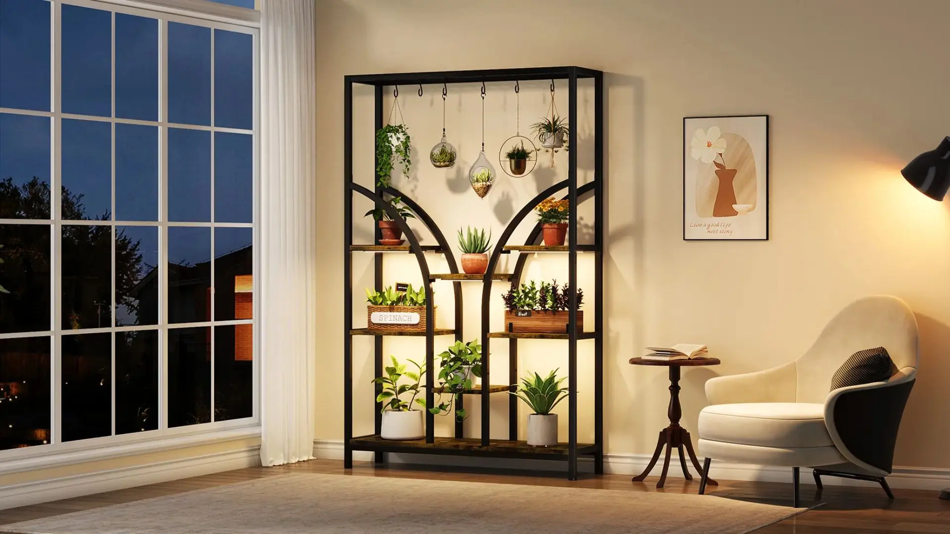 A modern black metal shelf unit displays various potted plants and hanging terrariums in a warmly lit room with a large window and a cream-colored armchair.