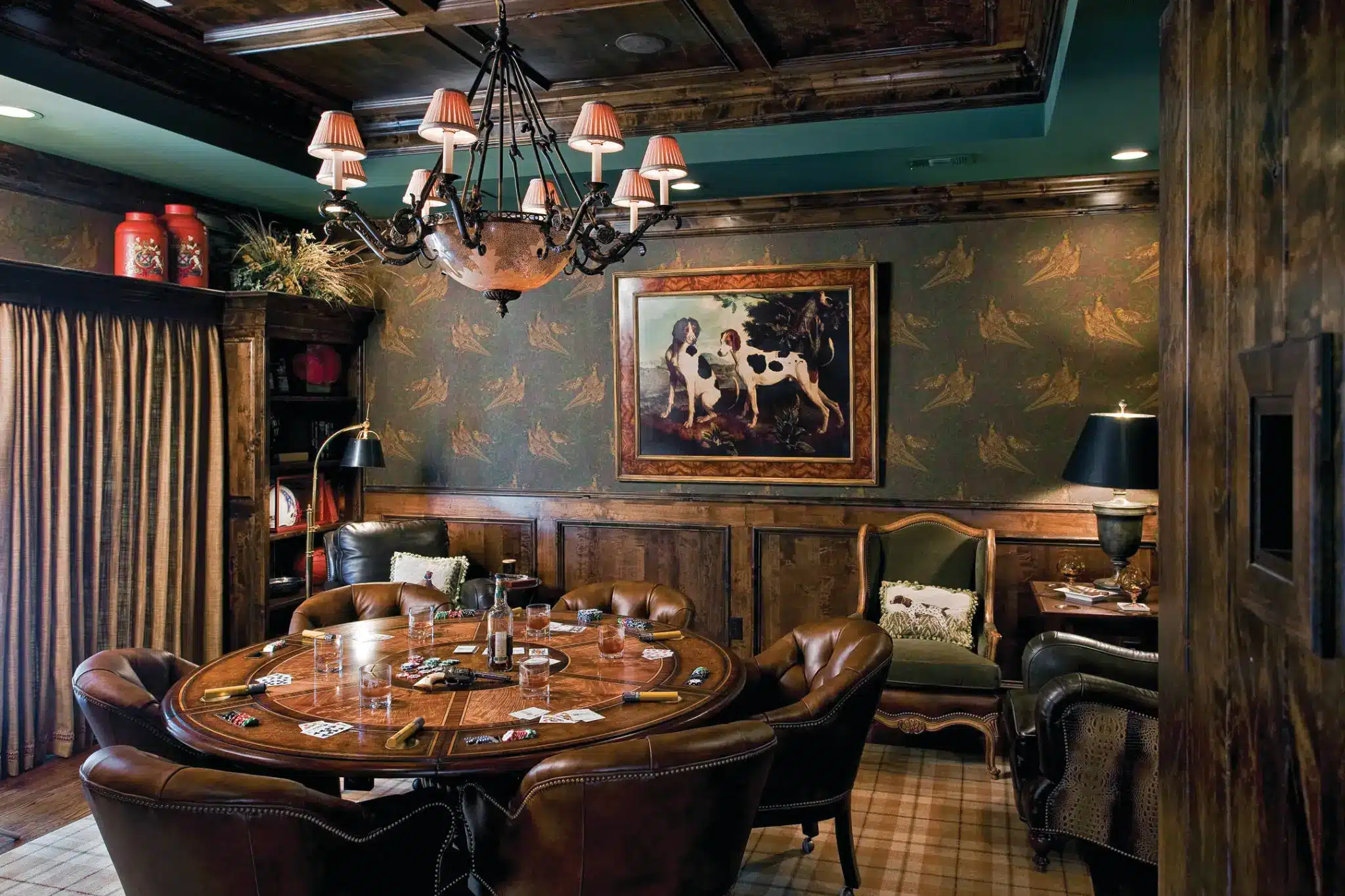 Poker table with leather chairs in rustic study with dog painting and vintage chandelier