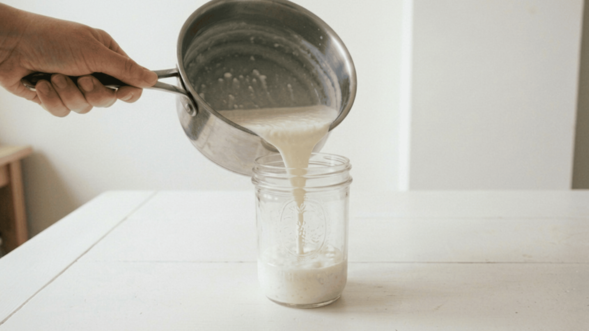 Yogurt mixture incubating in clean glass jar.