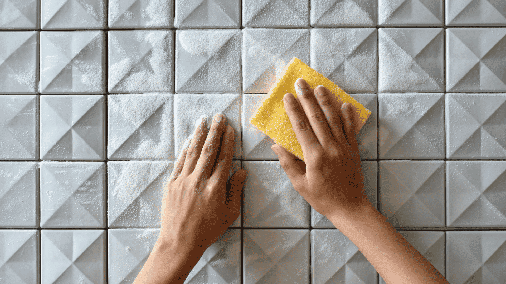 Hand applying baking soda paste on tile