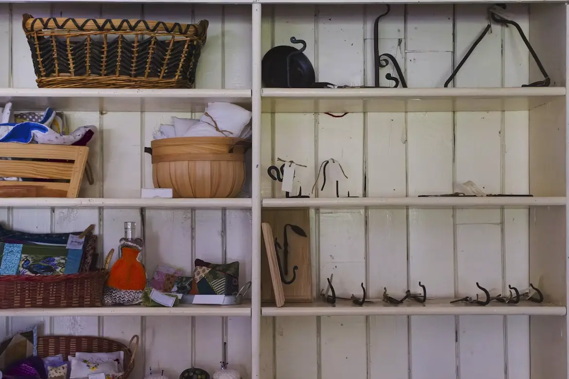 Wooden shelves displaying woven baskets, hooks, and colorful fabric items against painted wall