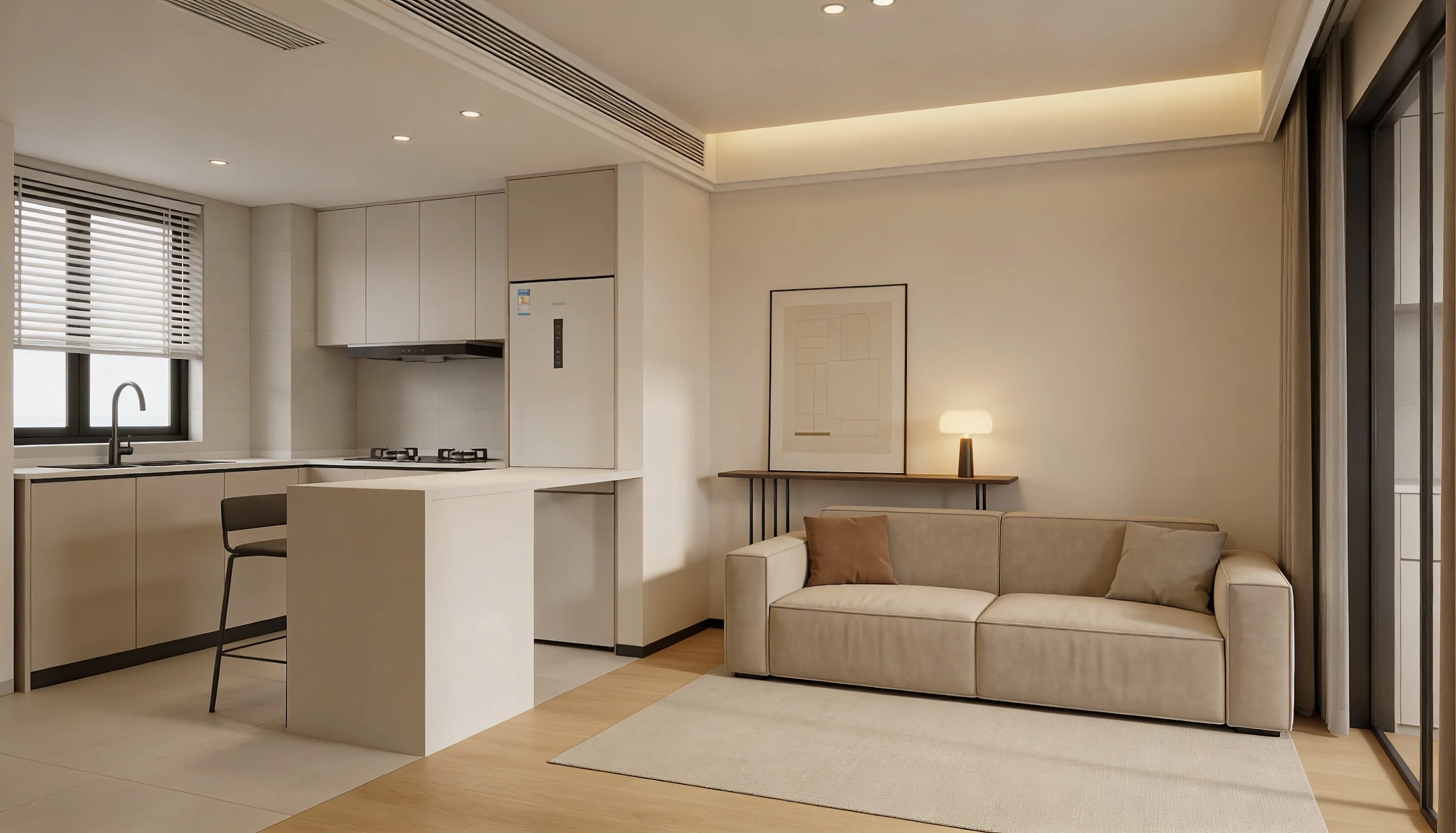 Open concept space with a beige sofa and a side table lamp. Adjacent is a modern kitchen with a bar stool and sleek appliances
