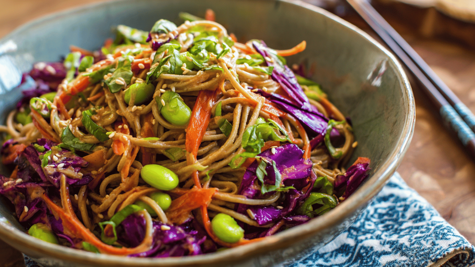 Cold soba noodles with shredded cabbage, carrots, and edamame tossed in a spicy peanut dressing.
