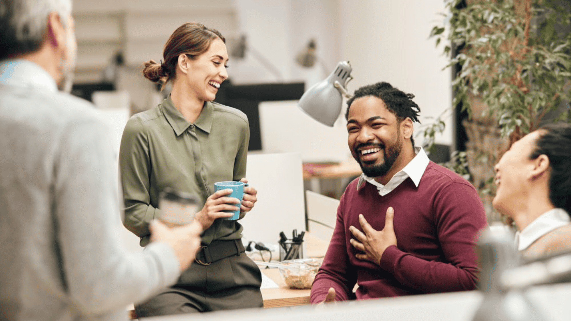 Team high-fiving in bright office, showing corporate wellness and collaboration.