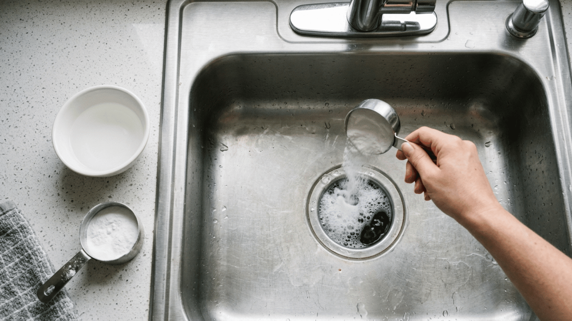 baking soda and vinegar fizzing in a kitchen sink drain