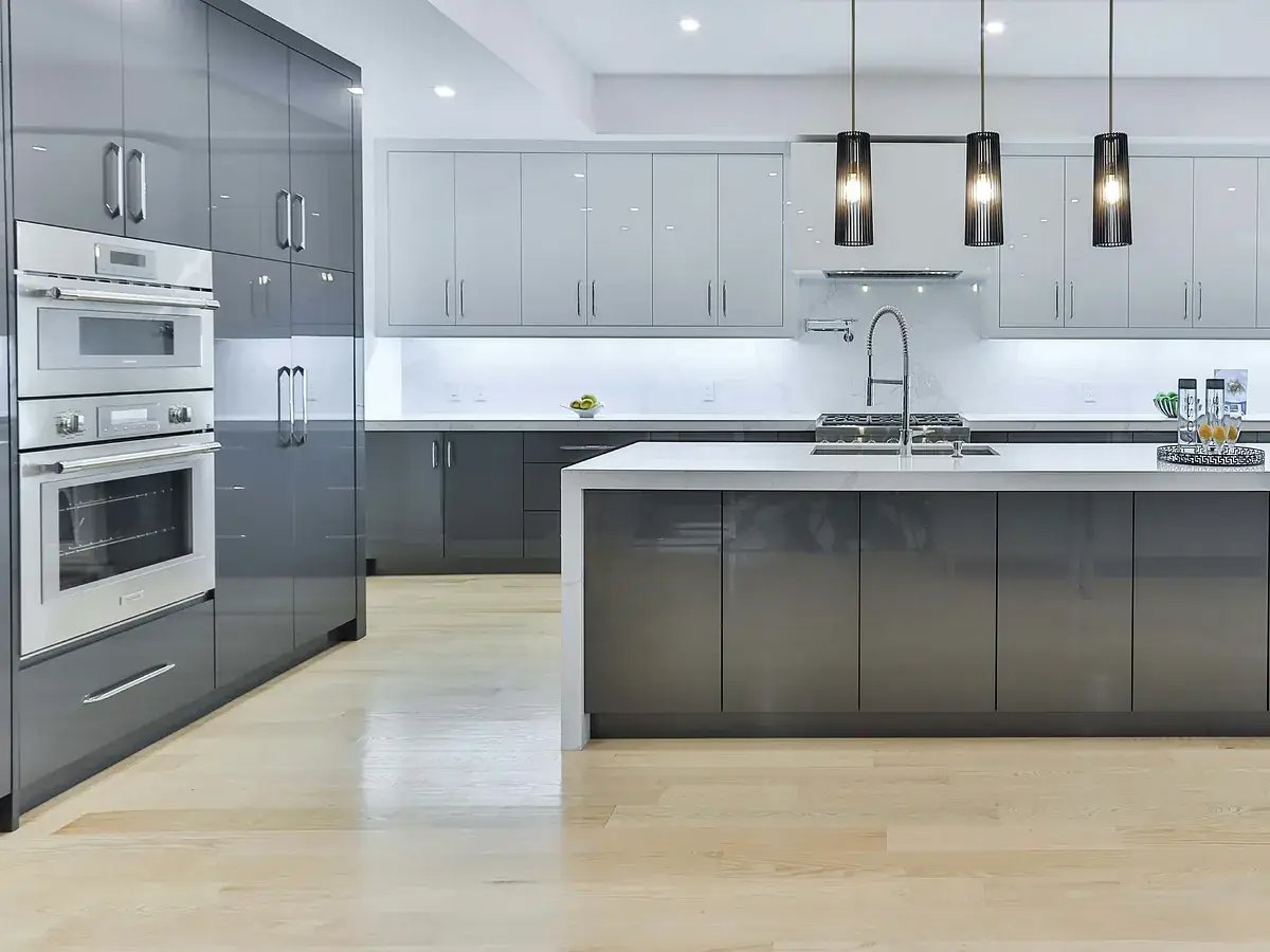 Modern kitchen with gray cabinets, stainless steel appliances, and pendant lighting over island countertop