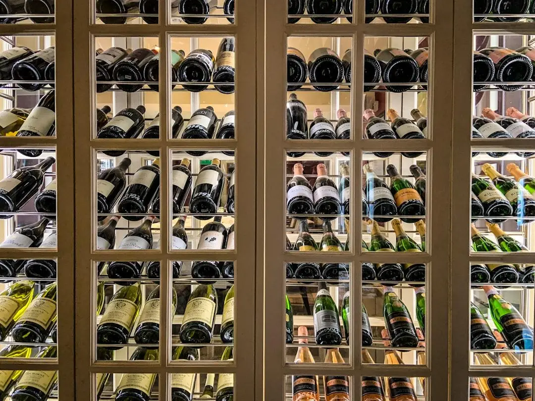 Wine bottles organized on shelves in a well-lit wine cellar display