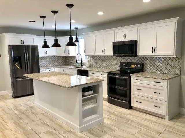 Modern kitchen with large island, granite countertops, stainless steel appliances, and pendant lighting
