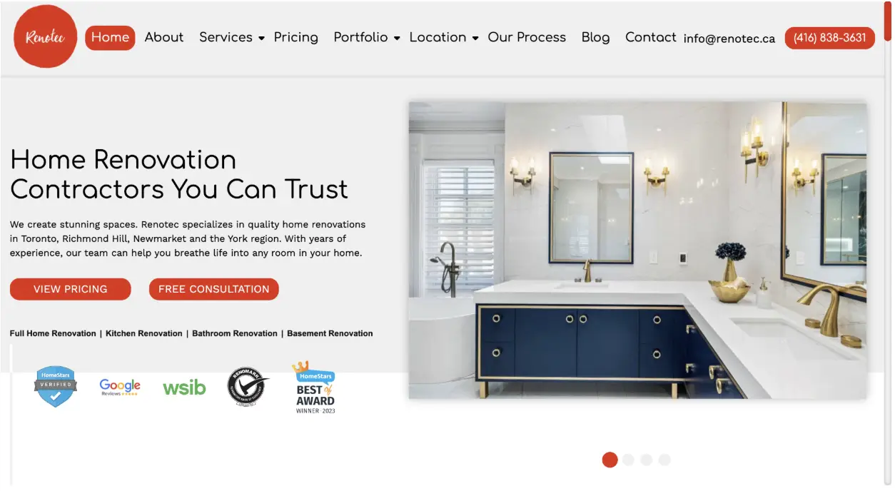Modern bathroom with dual sinks, navy blue cabinets, and gold fixtures in bright lighting