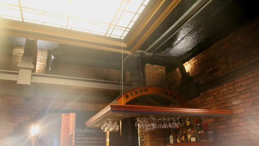 Ceiling-mounted wine glass rack with wooden design in warm, rustic brick interior bar