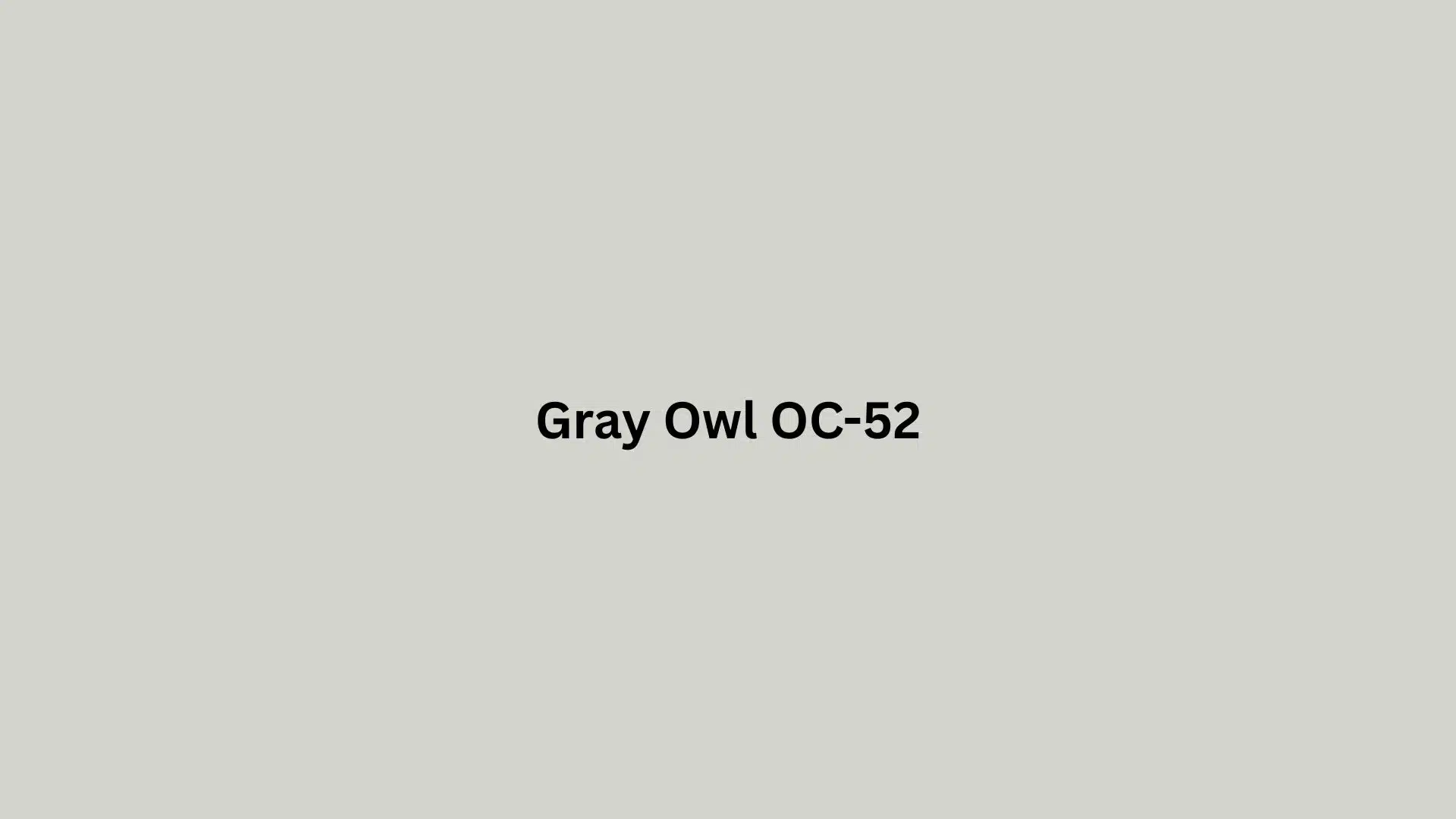 A gray owl perched on a branch, showcasing its distinctive feathers and large, expressive eyes.