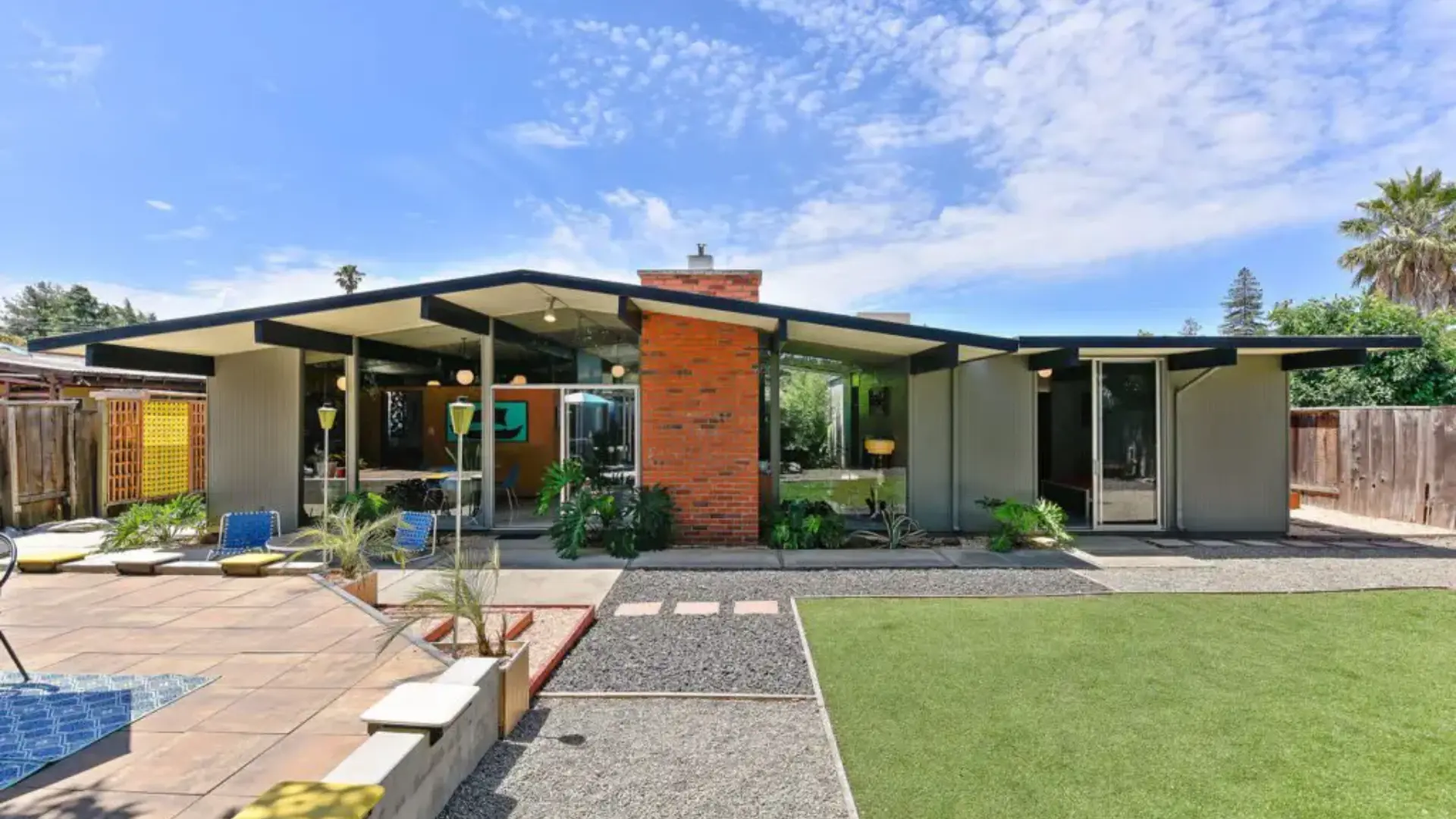 Classic Eichler Home California featuring <echighlighted>mid century modern architecture exposed beams floor to ceiling glass walls brick chimney and landscaped front yard