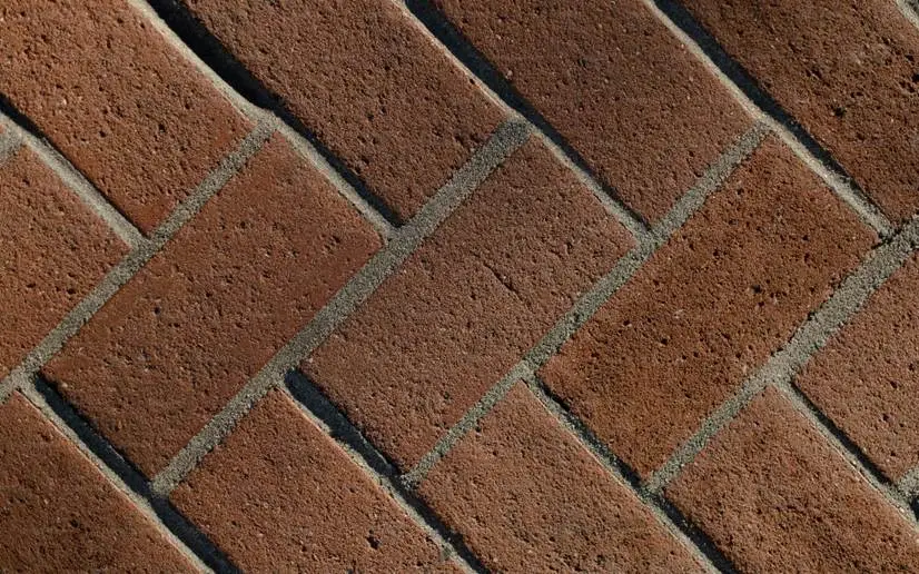Diagonal red brick pattern with gray mortar lines in bright outdoor setting
