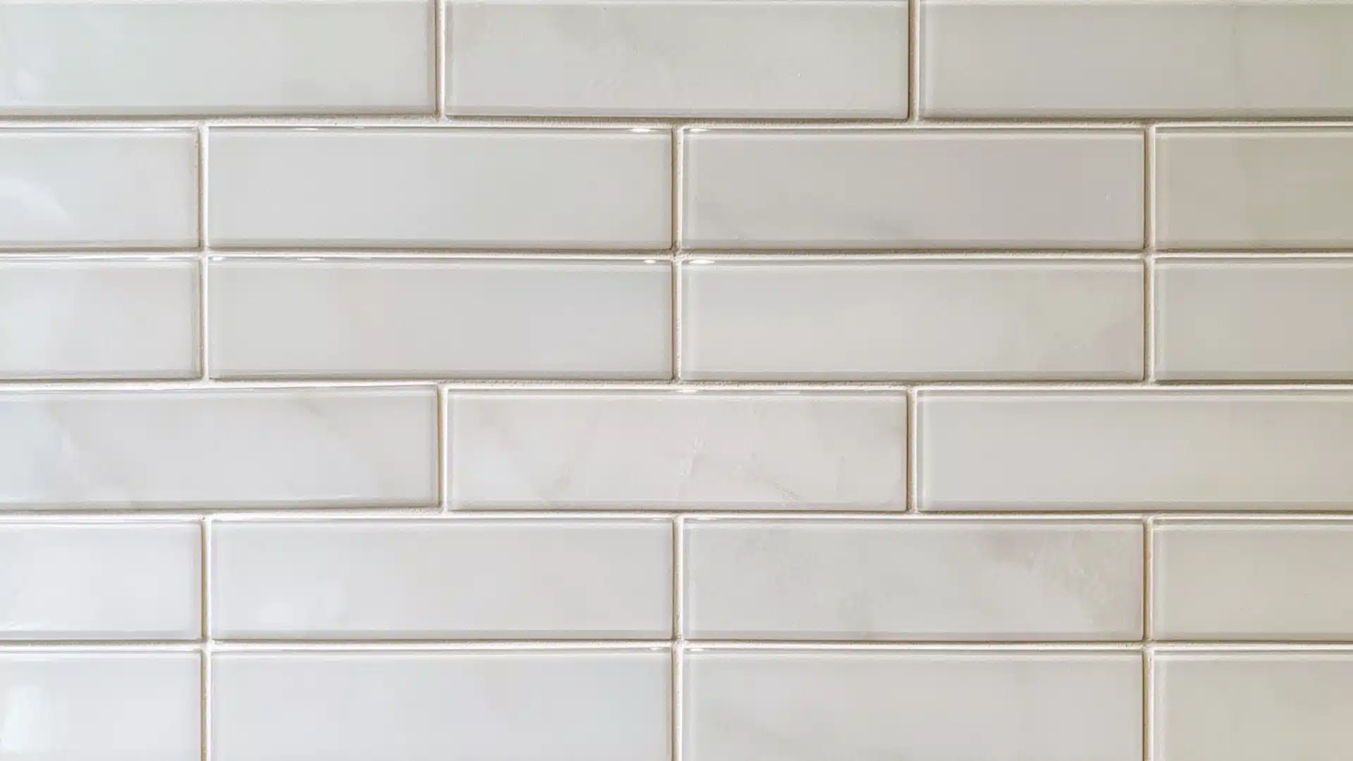 Close-up of white glass subway tiles with smooth, narrow unsanded grout lines
