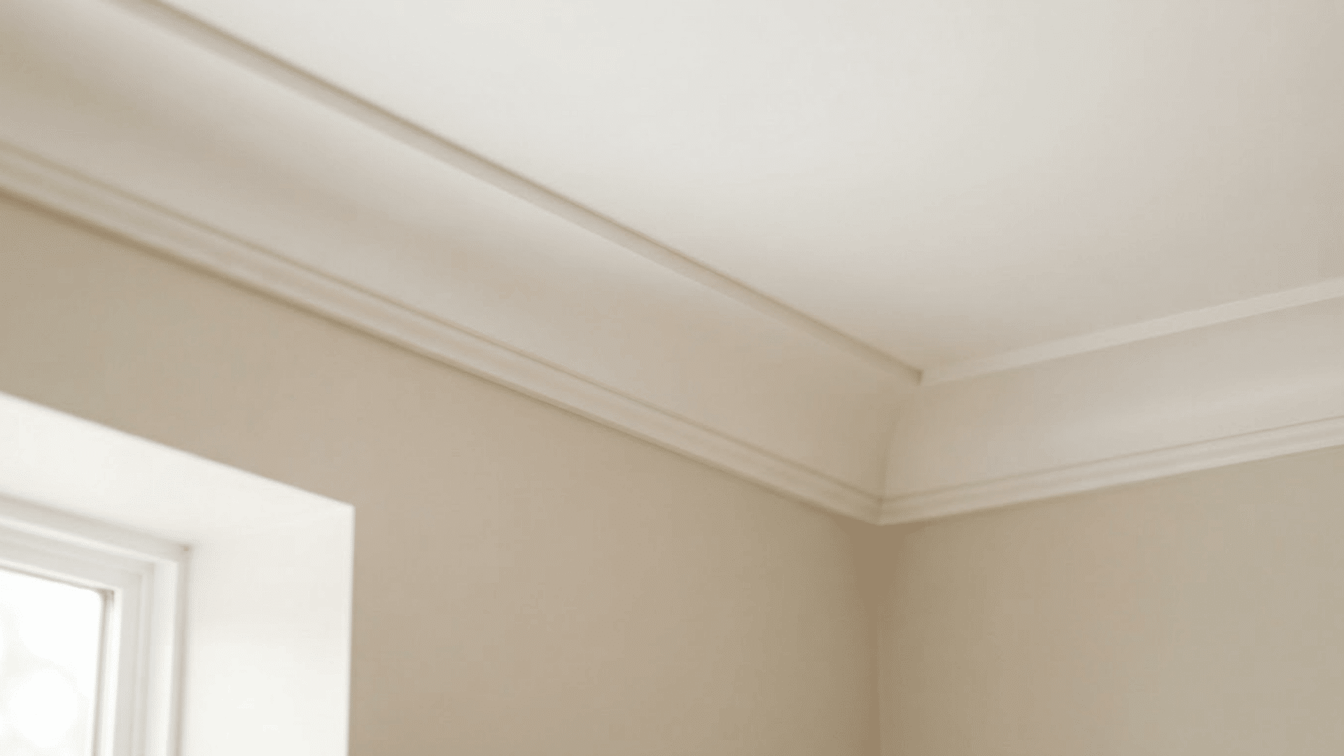 cove crown molding with a smooth curved profile between beige walls and a white ceiling