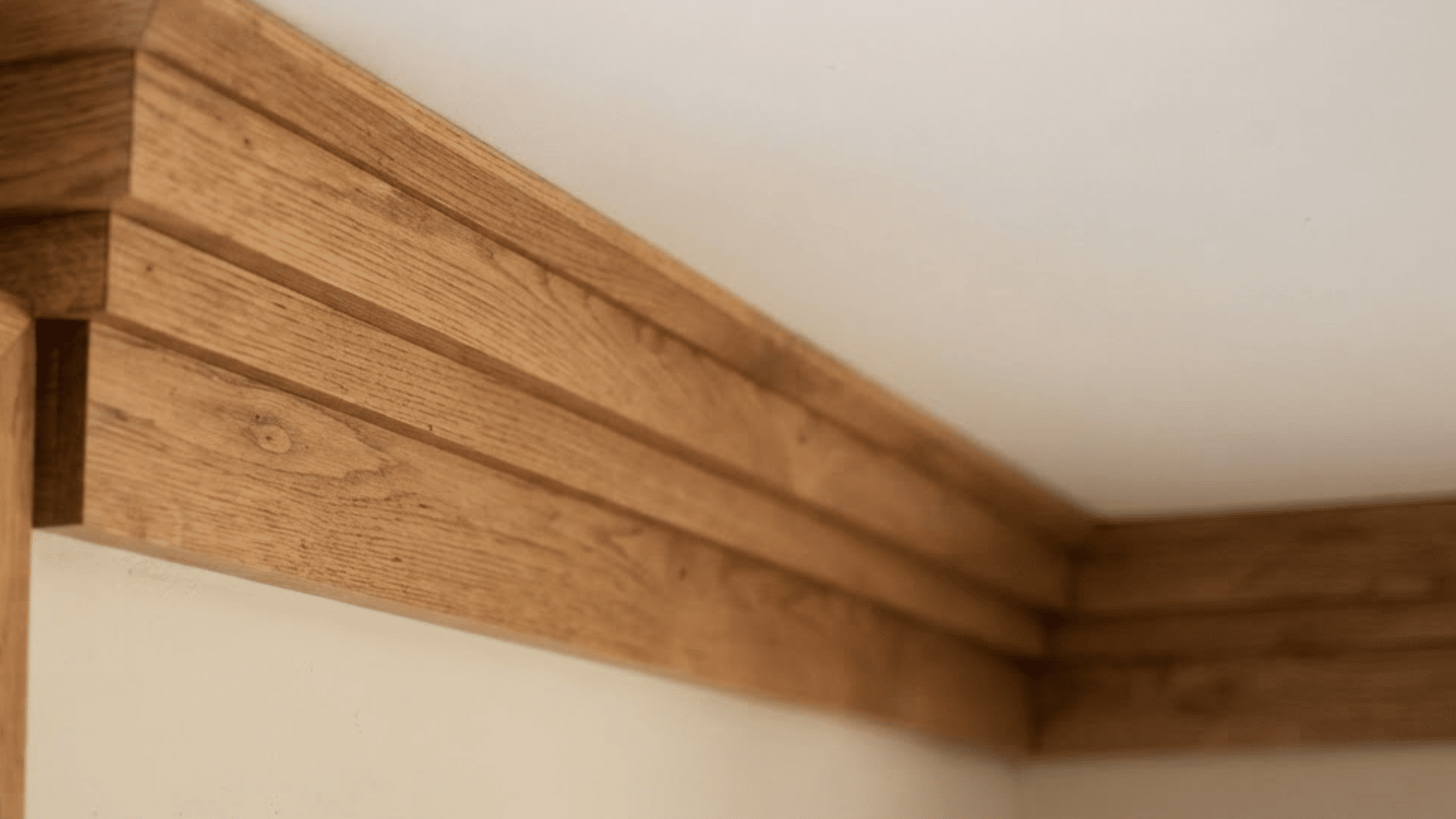 craftsman crown molding in natural wood with layered trim beside a matching window frame