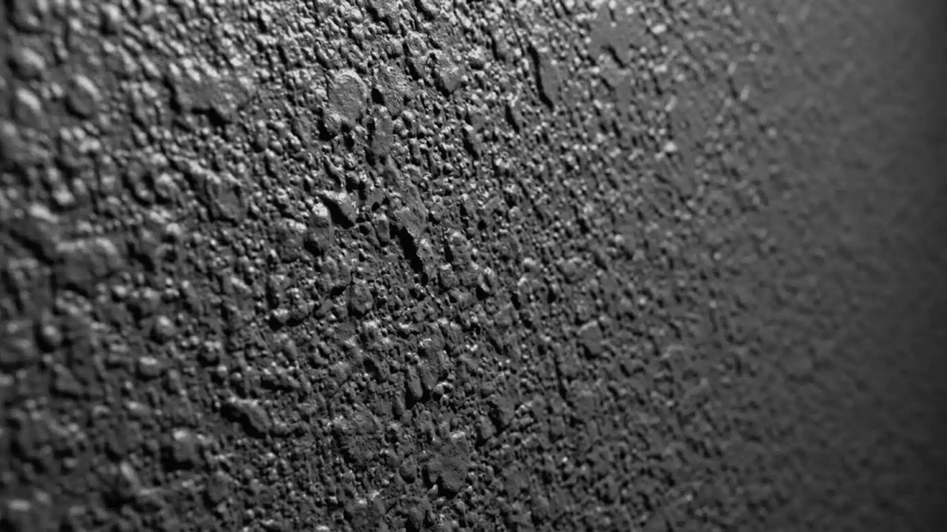 Extreme close-up of heavy, thick orange peel drywall texture in grey
