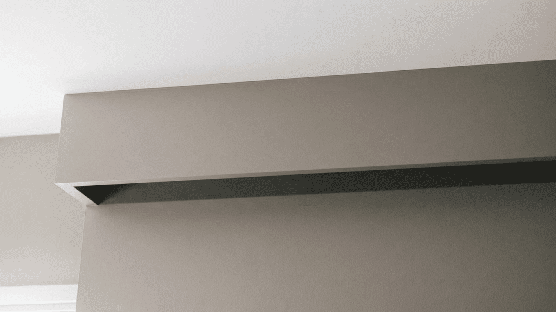 flat crown molding with a wide simple white profile running along a light neutral wall