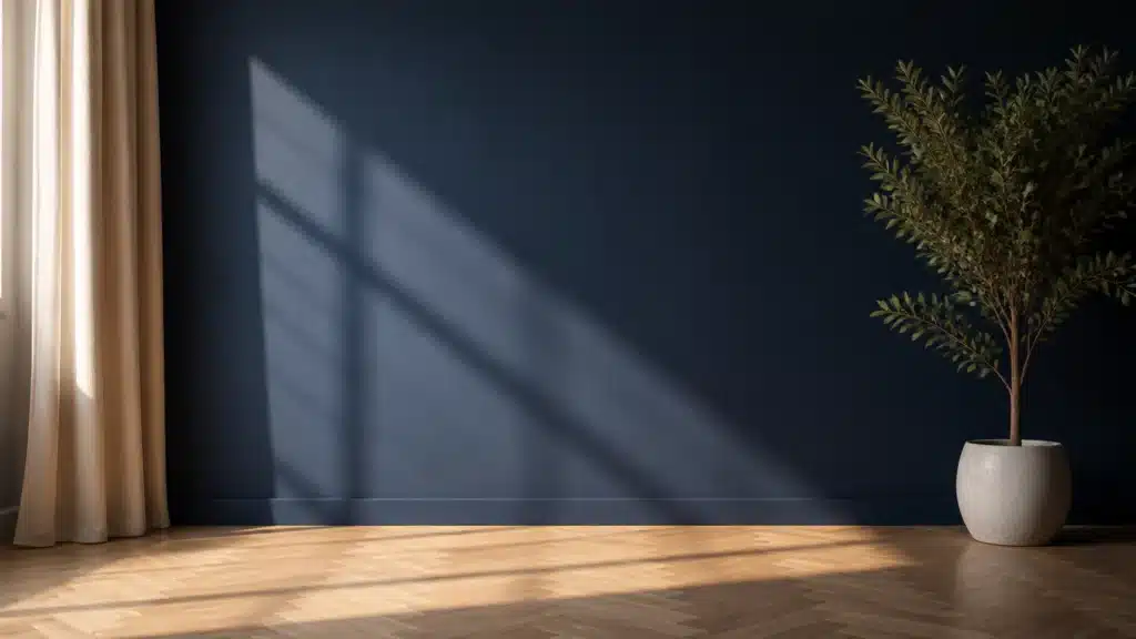 Benjamin Moore Hale Navy wall in a modern living room with a neutral armchair, wooden side table, indoor plant, and warm natural light.