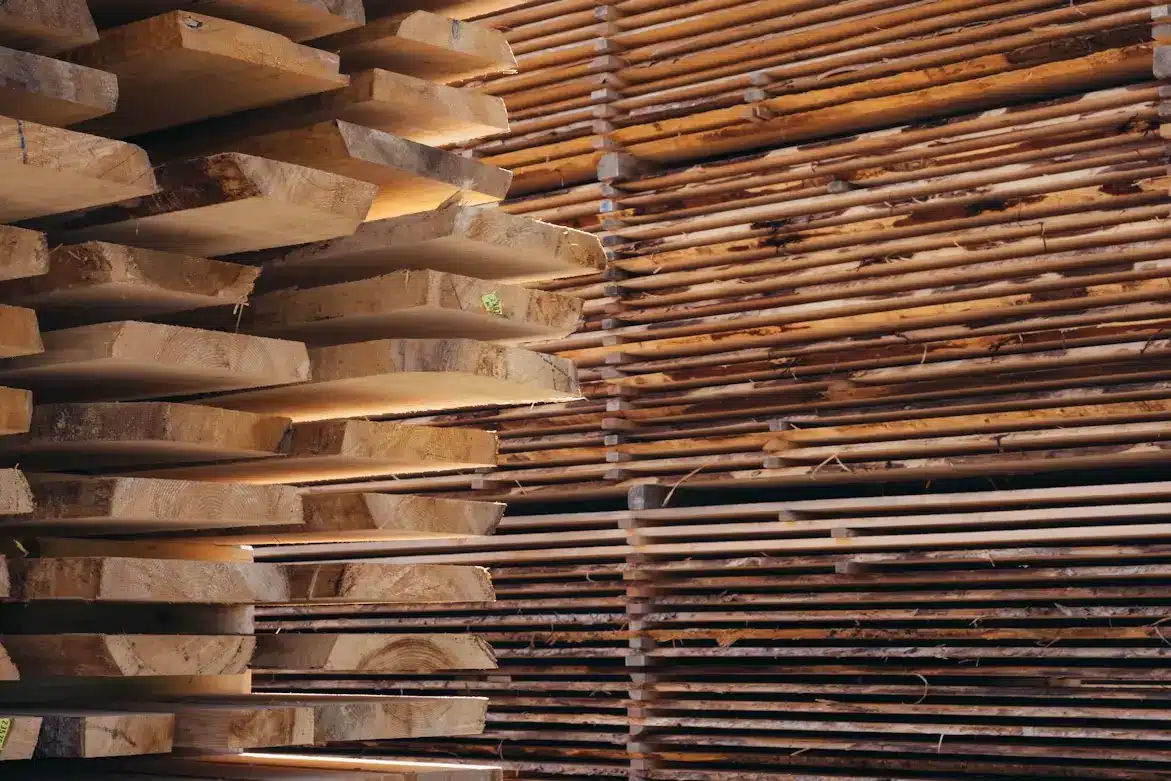 Stacked wooden planks in an indoor lumber storage area with warm lighting