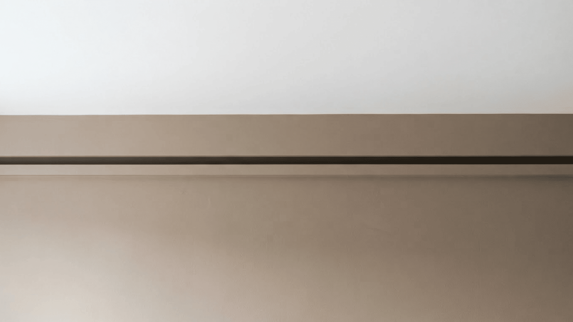 shadow line crown molding with a recessed gap between a white ceiling and taupe wall