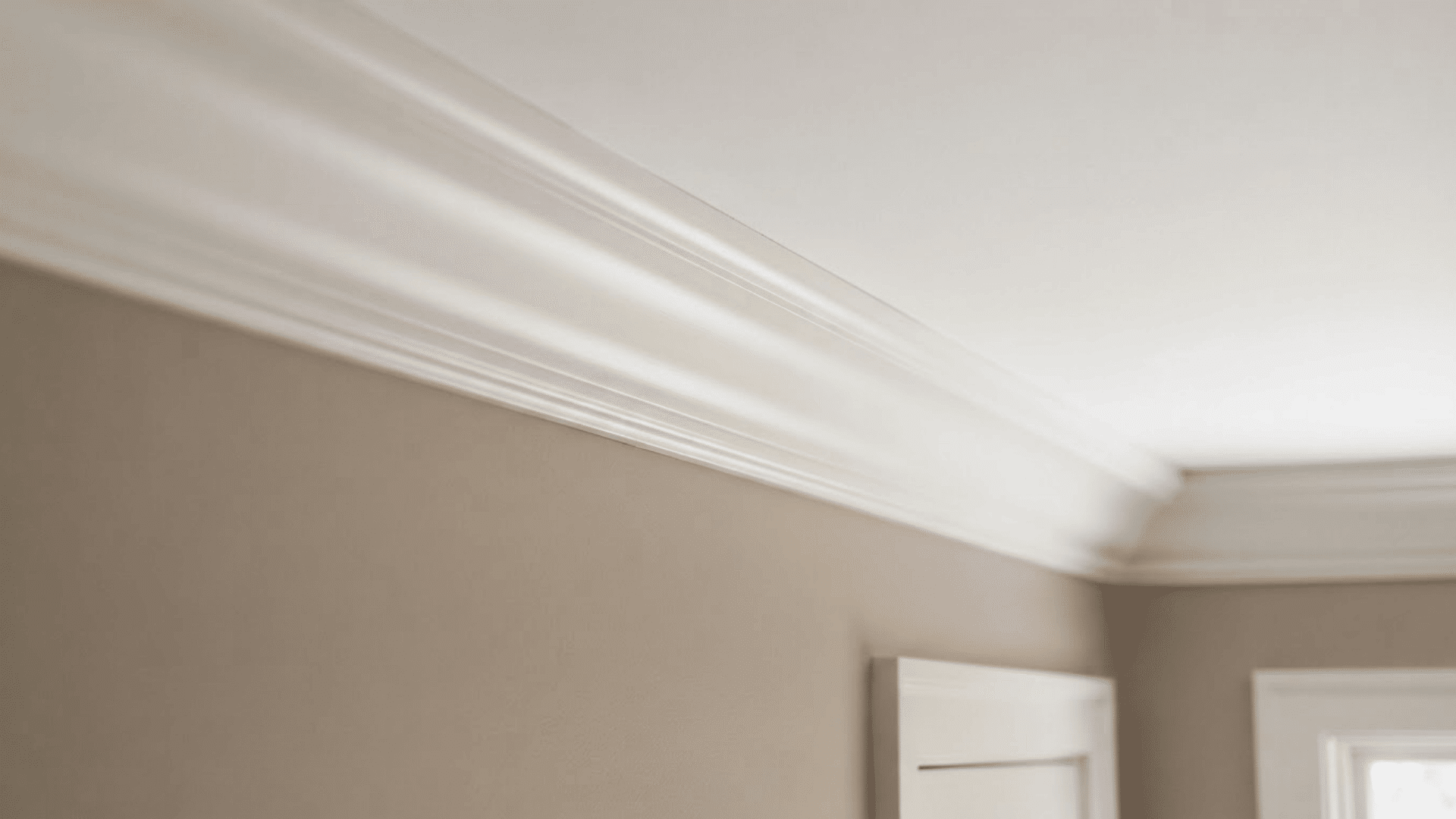 traditional crown molding with curved white trim running along a soft beige interior wall