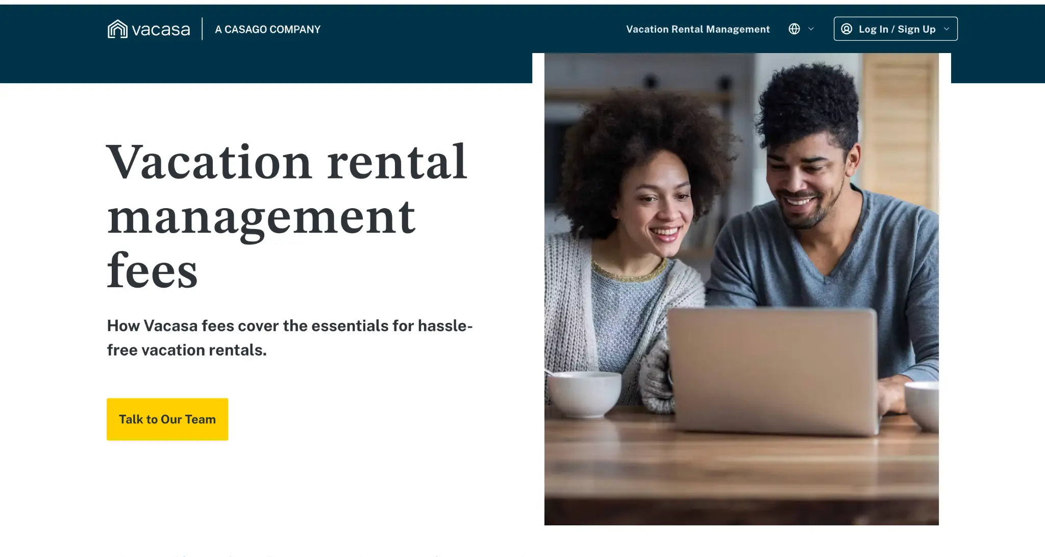 Couple smiling while looking at laptop screen in cozy living room setting