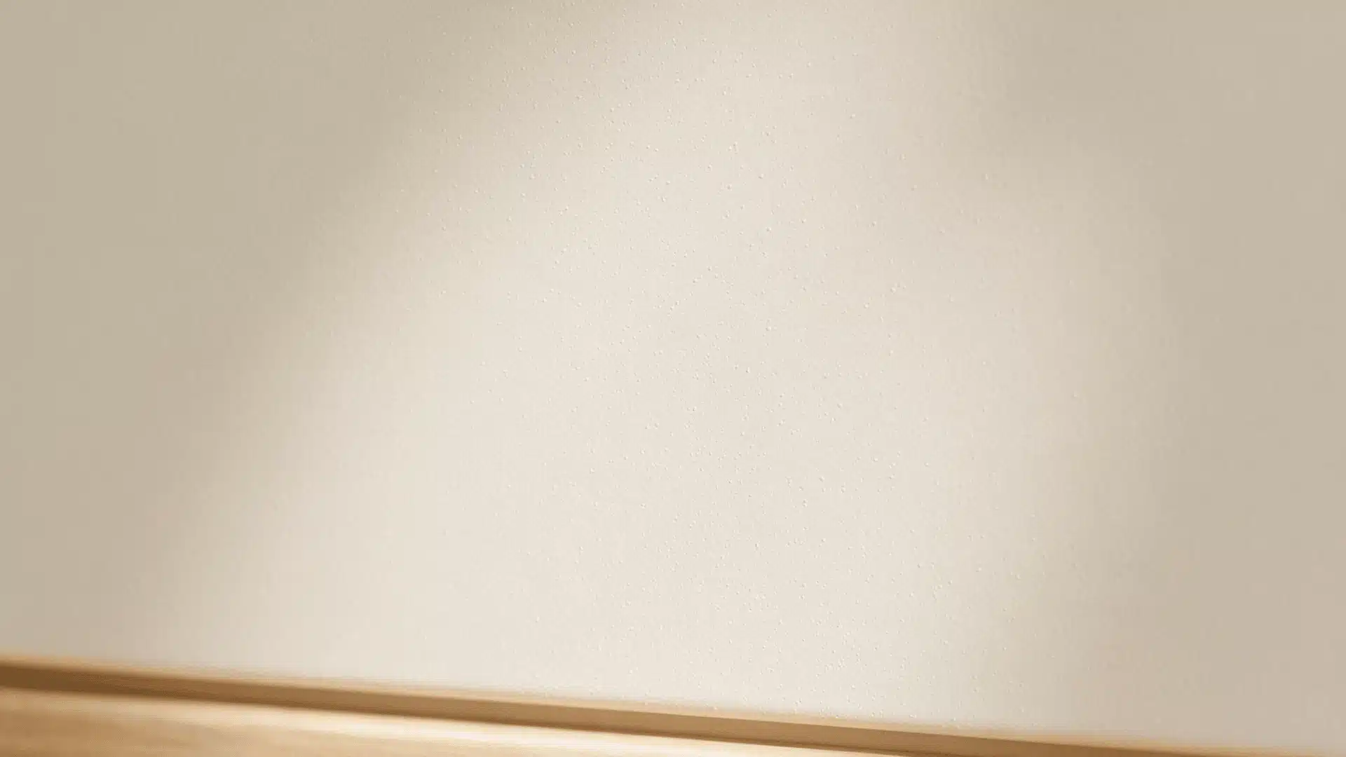 Very fine orange peel wall texture with soft lighting and wooden trim