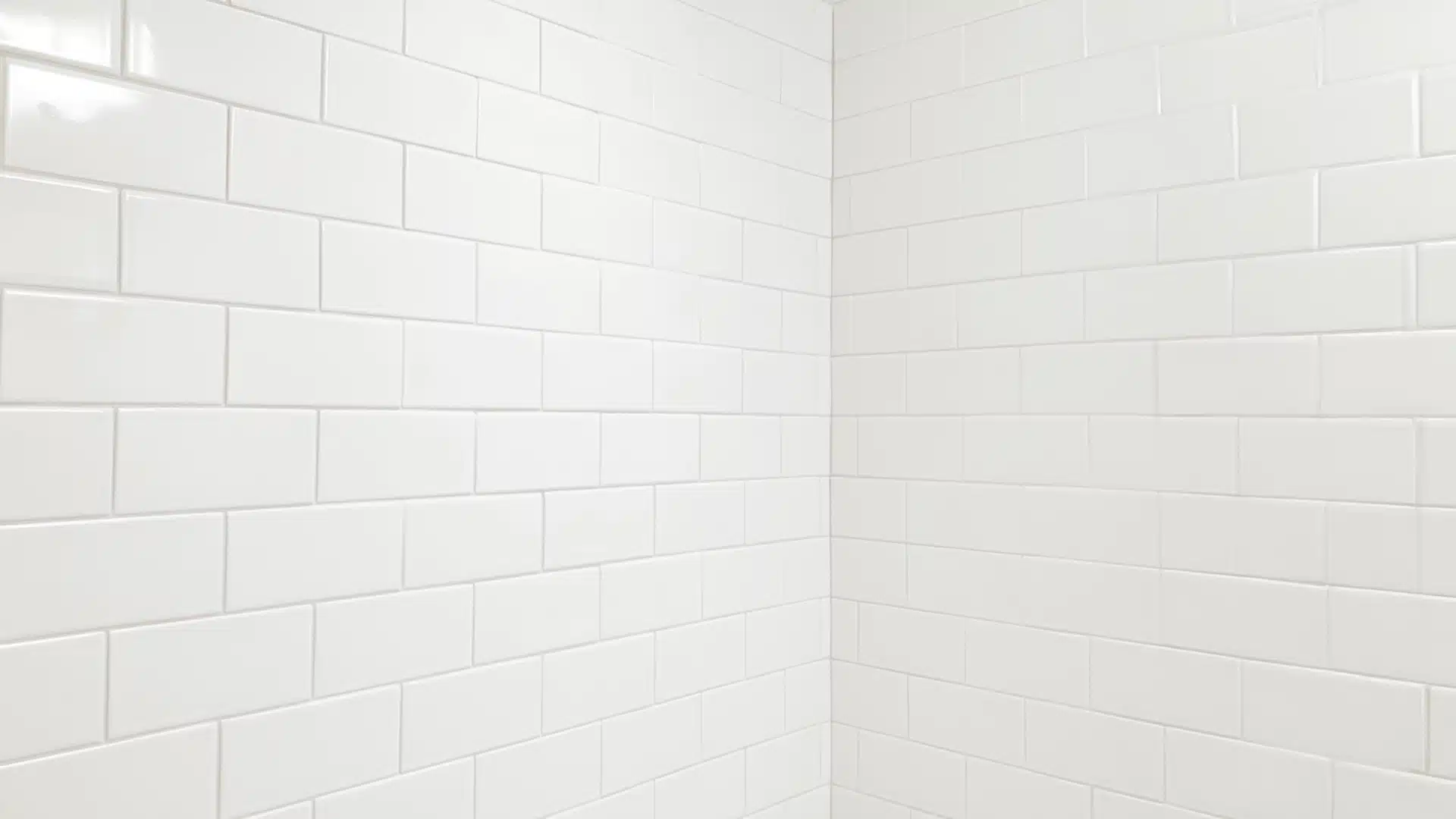 Close-up corner view of white subway wall tiles with clean white grout lines