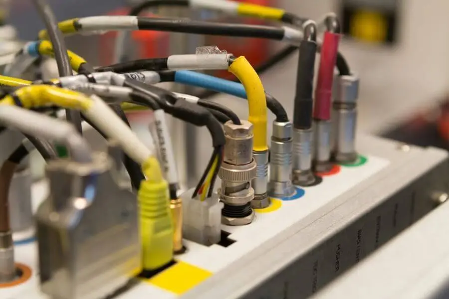 Color-coded cables plugged into electronic device in a technical setup environment