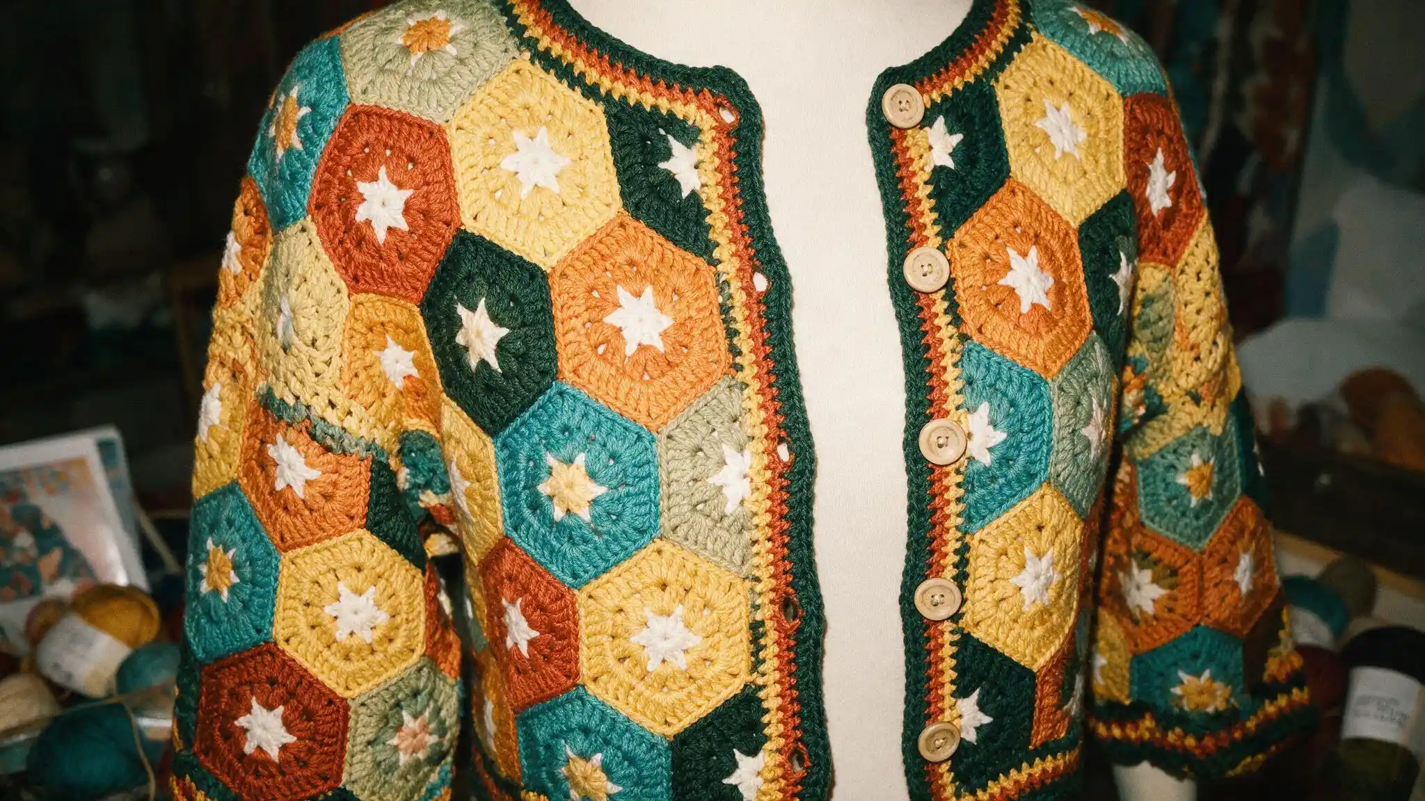 A vibrant hexagon cardigan in granny style crochet, embellished with colorful stars, showcasing a unique and playful design.