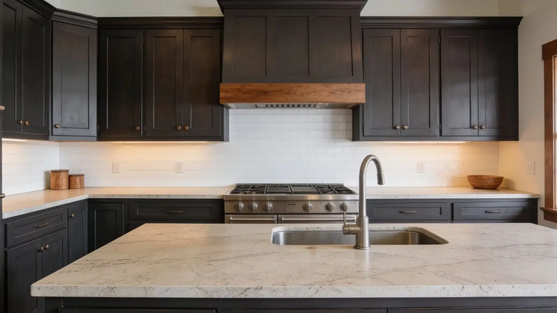 A modern kitchen featuring sleek black cabinets and elegant white countertops.
