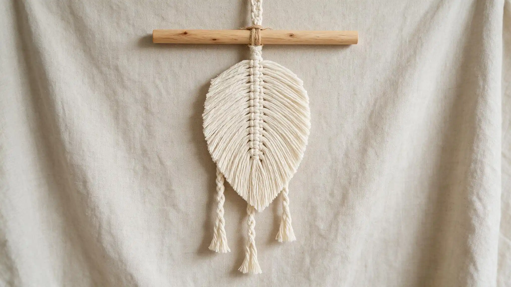 Macrame feather wall hanging with braided center and decorative hanging tassels