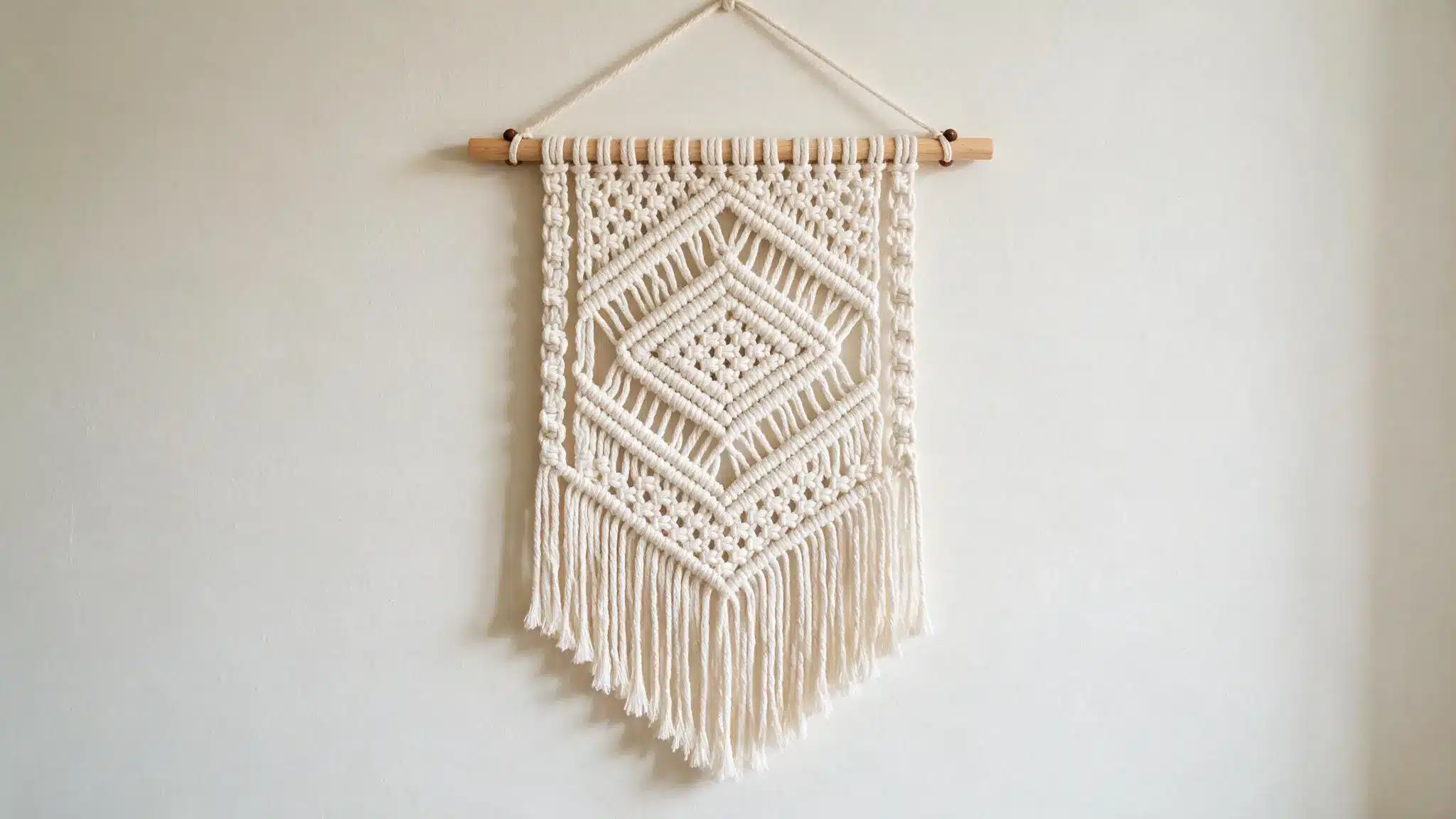 Macrame wall hanging with intricate geometric patterns and long decorative fringe