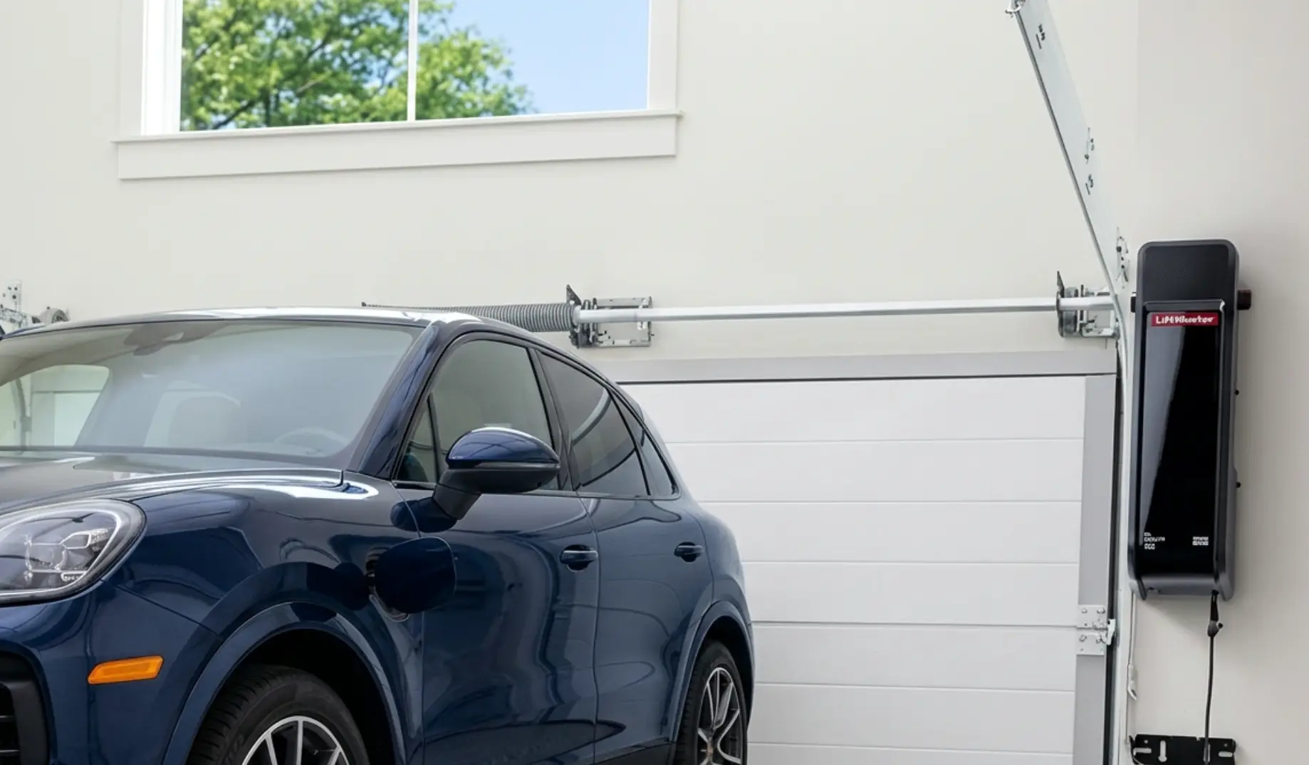 Blue SUV parked inside a garage with white door and ceiling-mounted opener